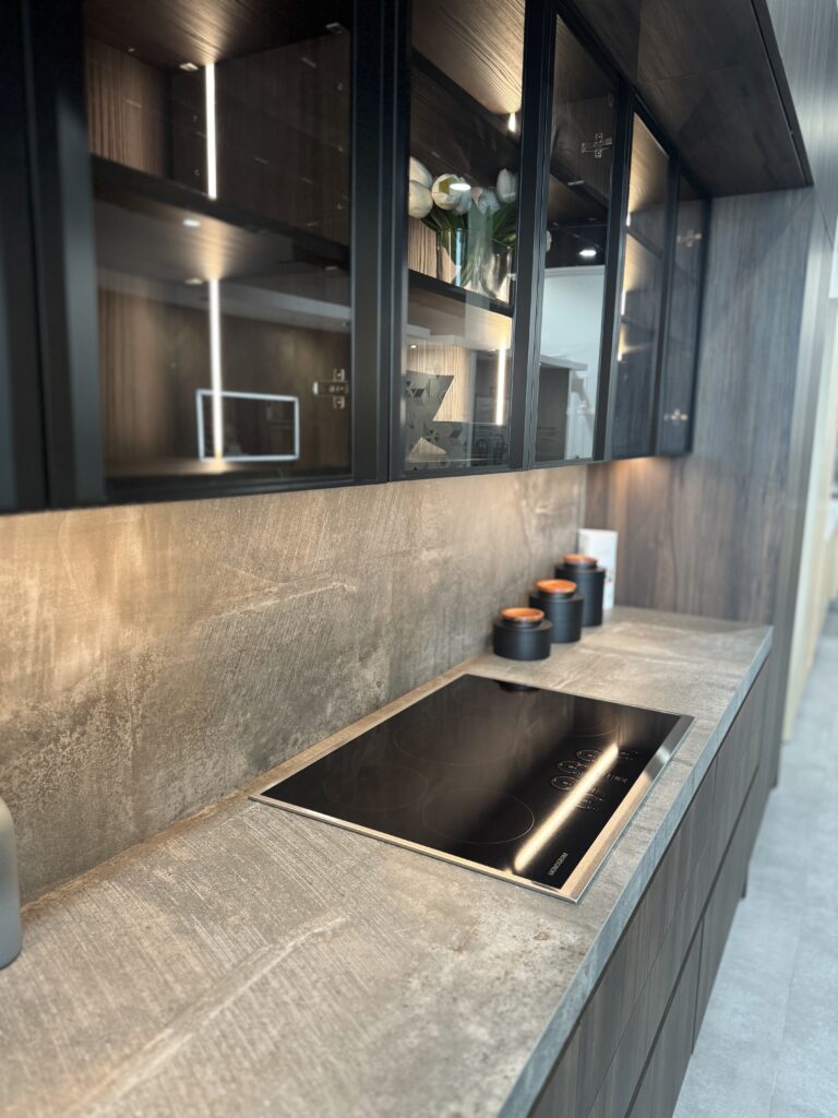 Dark cabinetry with integrated lighting and a stone countertop